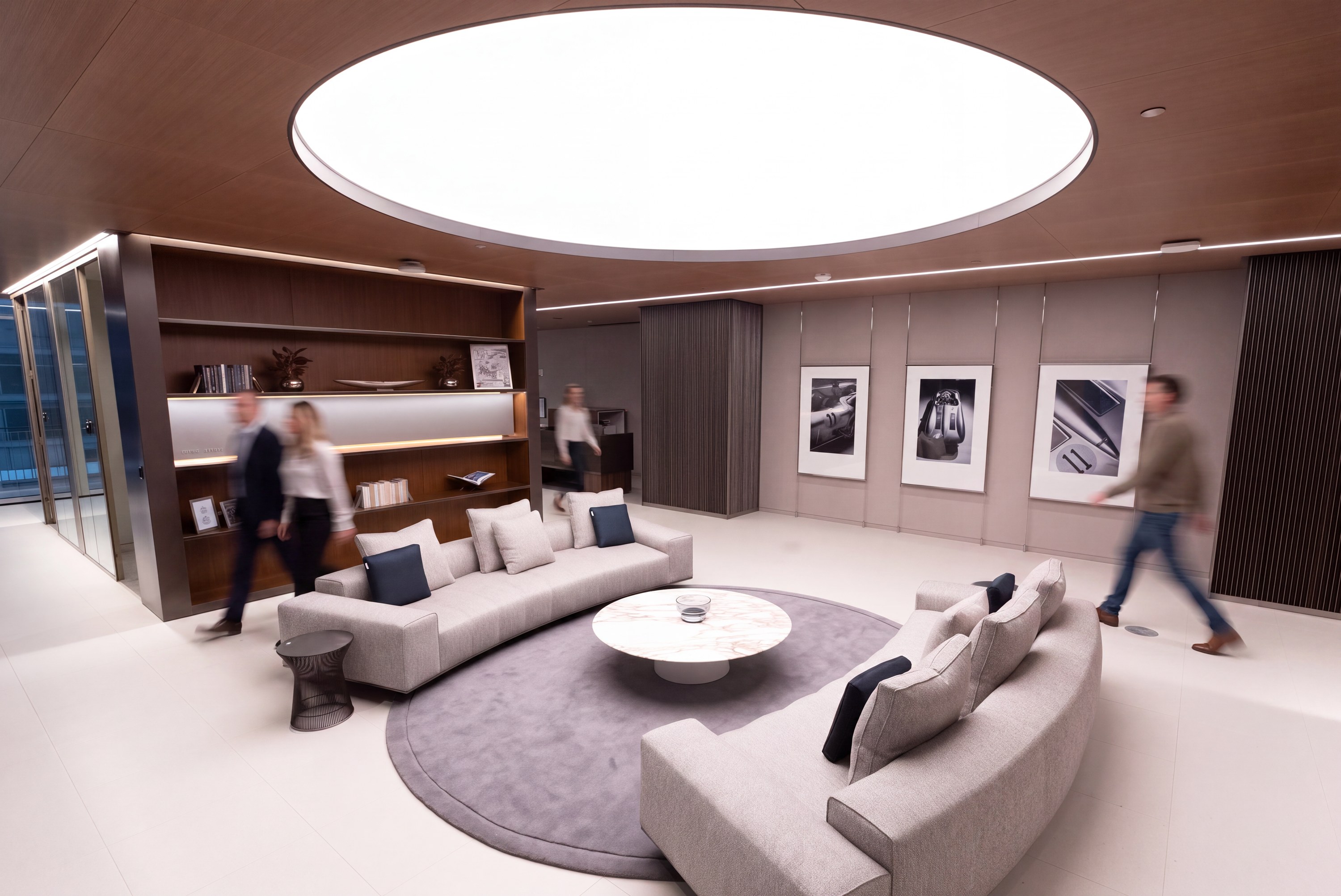 Lounge beneath a circular skylight in walnut and wool