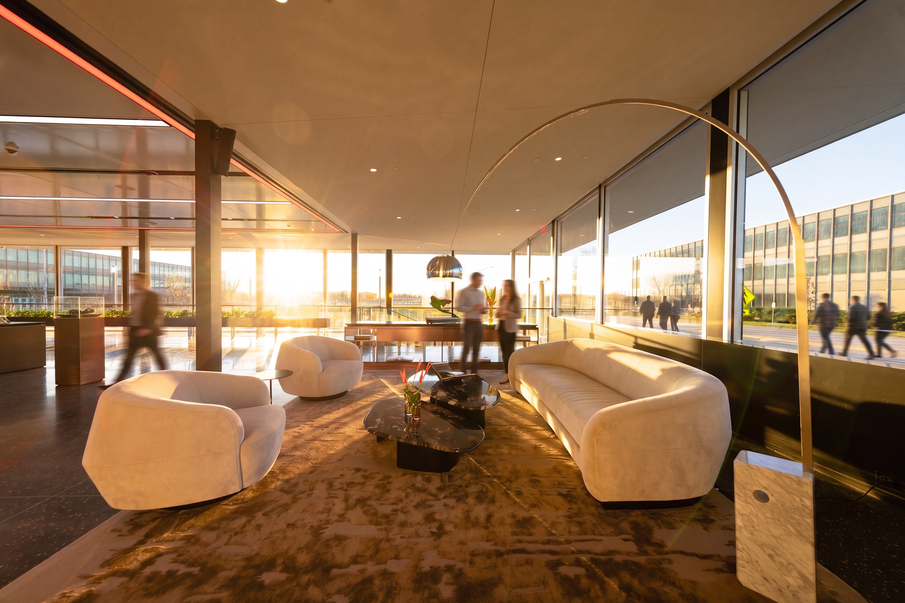 Curved seating in low golden light along a glass wall