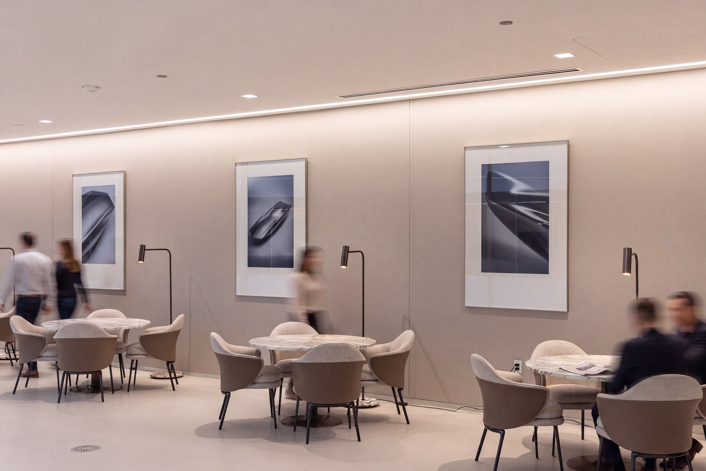 Café tables along an art wall in warm neutrals